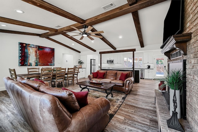 living room featuring ceiling fan, lofted ceiling with beams, and light hardwood / wood-style flooring