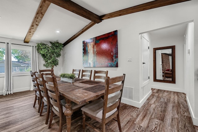 dining area featuring lofted ceiling with beams and wood-type flooring