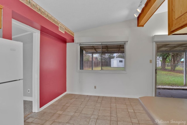 interior space featuring track lighting and vaulted ceiling