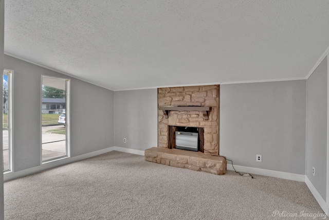 unfurnished living room with ornamental molding, a fireplace, a textured ceiling, and carpet