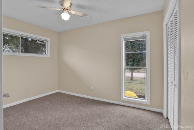 carpeted empty room with a textured ceiling and ceiling fan