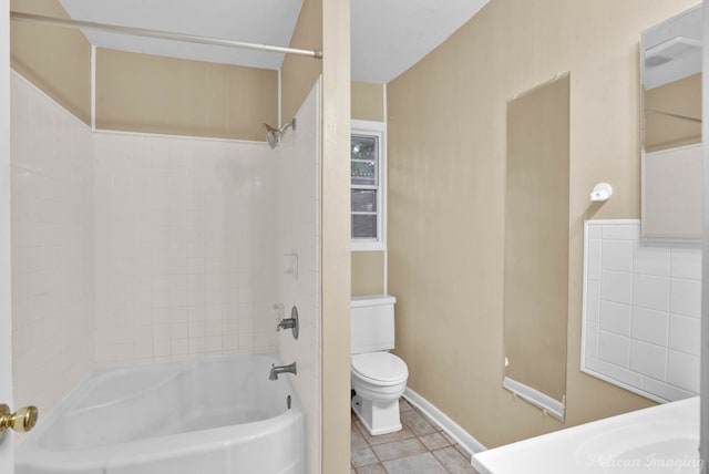 bathroom with tiled shower / bath combo and toilet