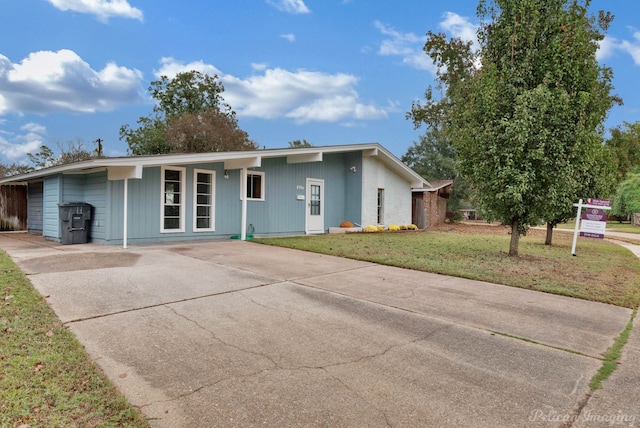 ranch-style house featuring a front lawn and a carport