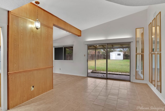 spare room featuring lofted ceiling with beams, a textured ceiling, and tile patterned flooring