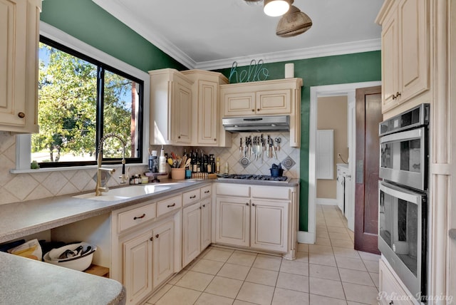 kitchen with cream cabinetry, sink, crown molding, light tile patterned floors, and tasteful backsplash