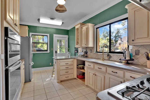 kitchen with crown molding, freestanding refrigerator, light countertops, and a sink