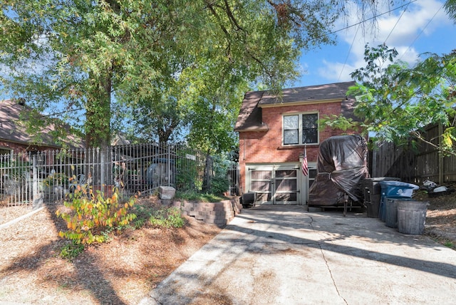 view of home's exterior with brick siding, fence, and driveway