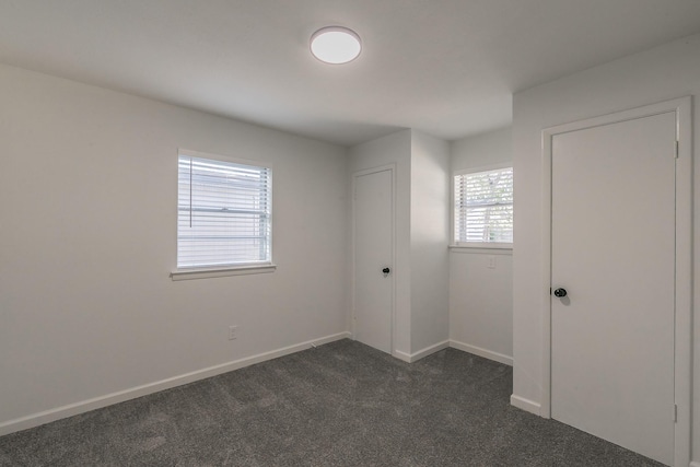 empty room featuring dark carpet