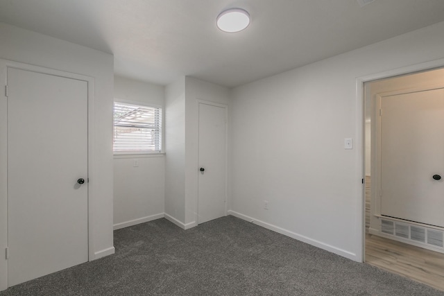 unfurnished room featuring dark carpet