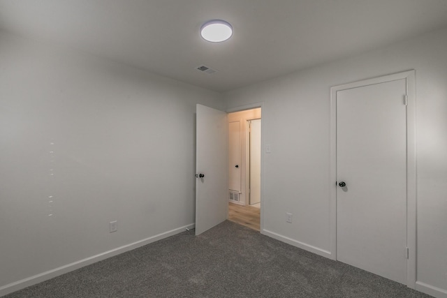 unfurnished bedroom featuring dark colored carpet