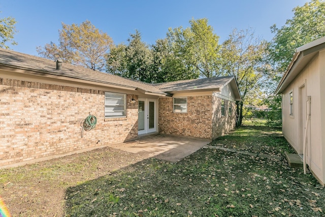 back of property featuring a lawn and french doors