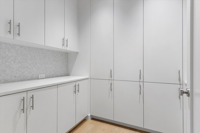 interior space featuring backsplash and hardwood / wood-style flooring