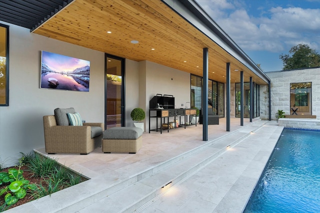 view of swimming pool with an outdoor kitchen and a patio area