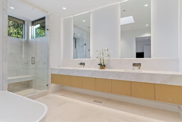 bathroom featuring tile patterned flooring, vanity, independent shower and bath, and a skylight