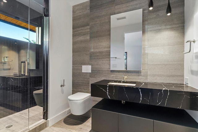 bathroom with walk in shower, vanity, tile walls, and toilet