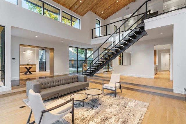 living room featuring hardwood / wood-style floors, wood ceiling, and a towering ceiling