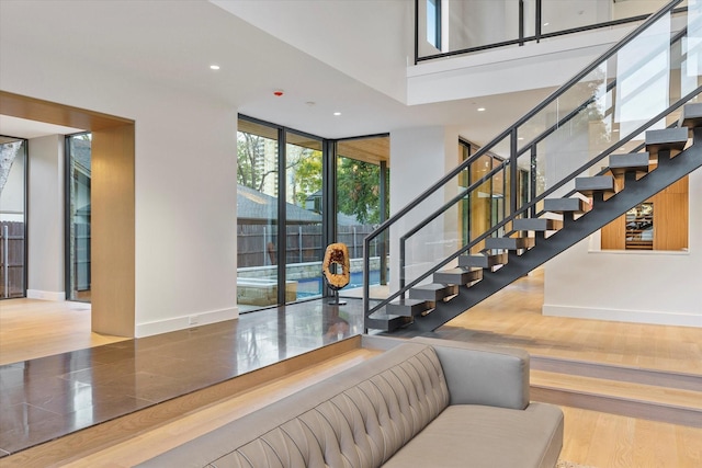 stairway with hardwood / wood-style floors and a wall of windows