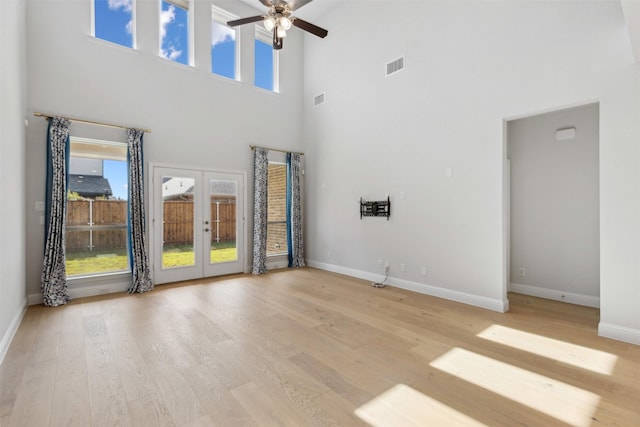 unfurnished living room featuring visible vents, baseboards, a high ceiling, french doors, and a ceiling fan