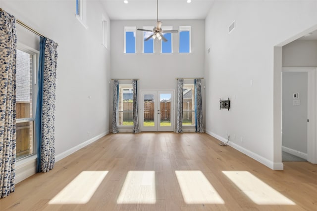 unfurnished living room with a high ceiling and a healthy amount of sunlight