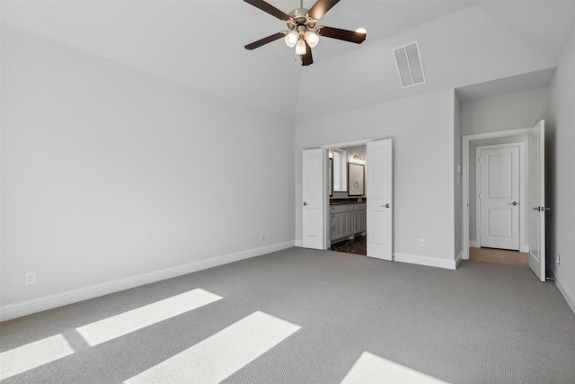 unfurnished bedroom with baseboards, carpet, a towering ceiling, and visible vents