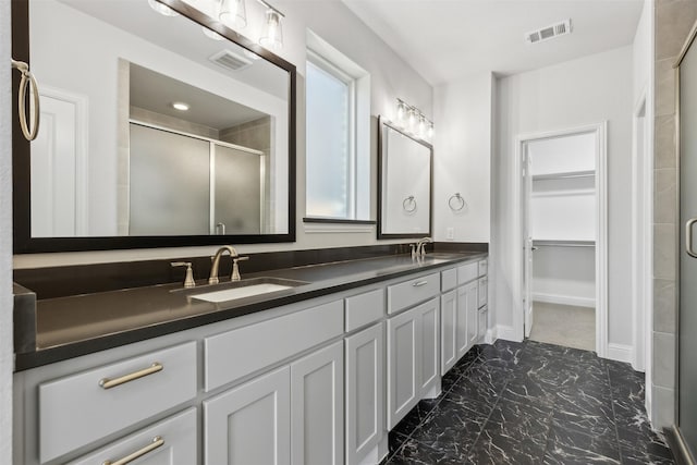 full bathroom with visible vents, a shower stall, and a sink
