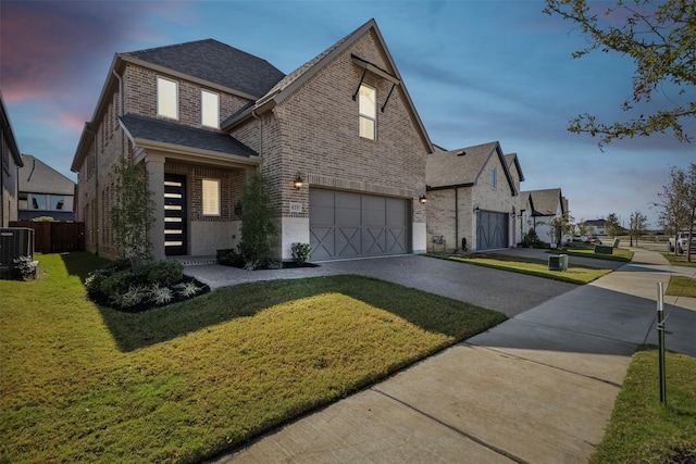 view of front of house featuring a garage, brick siding, central AC unit, concrete driveway, and a lawn
