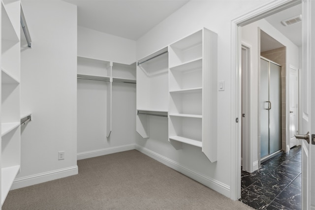 spacious closet featuring dark colored carpet