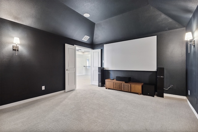 carpeted home theater room featuring lofted ceiling