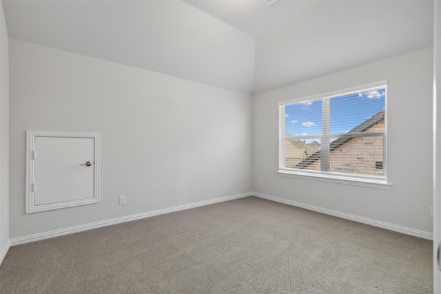 carpeted empty room with baseboards and lofted ceiling