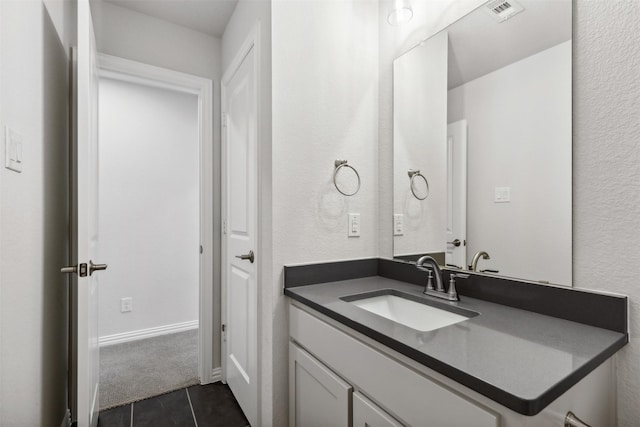 bathroom featuring vanity, tile patterned flooring, a textured wall, and visible vents