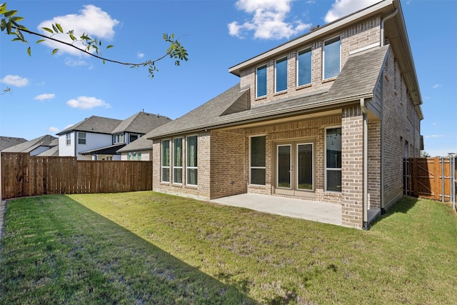 back of property featuring a lawn, brick siding, a fenced backyard, and a patio area