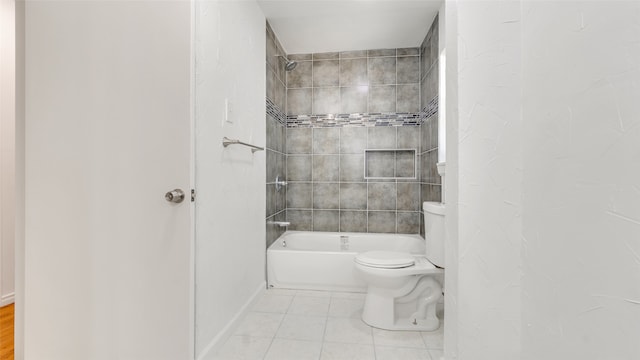 bathroom with toilet, tile patterned floors, and tiled shower / bath