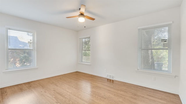 unfurnished room with light hardwood / wood-style floors, ceiling fan, and a wealth of natural light