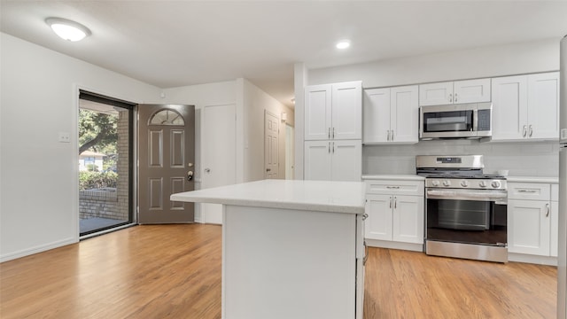 kitchen with a center island, white cabinetry, stainless steel appliances, and light hardwood / wood-style floors