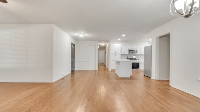 unfurnished living room featuring light hardwood / wood-style floors and a notable chandelier