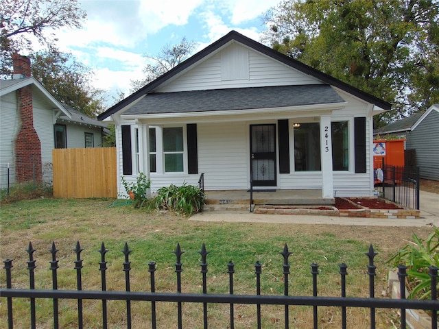 bungalow-style house featuring covered porch and a front lawn