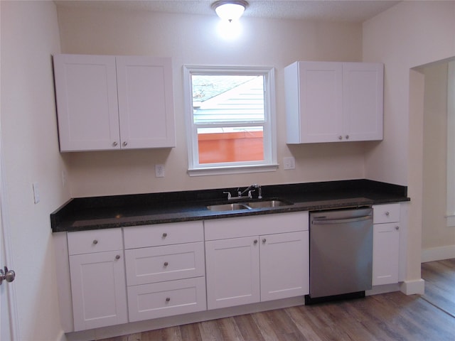 kitchen featuring light hardwood / wood-style flooring, sink, stainless steel dishwasher, white cabinets, and a textured ceiling