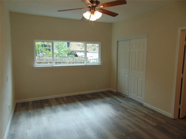 unfurnished bedroom with a closet, ceiling fan, and dark hardwood / wood-style flooring