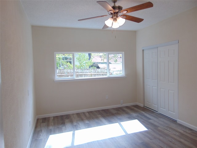 unfurnished bedroom featuring a closet, ceiling fan, a textured ceiling, and hardwood / wood-style floors