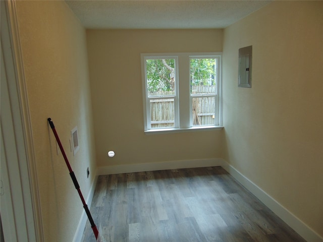 unfurnished room featuring hardwood / wood-style flooring and electric panel