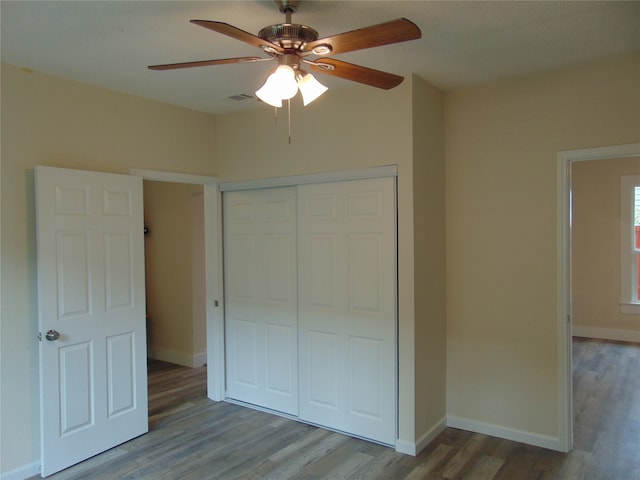 unfurnished bedroom with a closet, hardwood / wood-style flooring, and ceiling fan