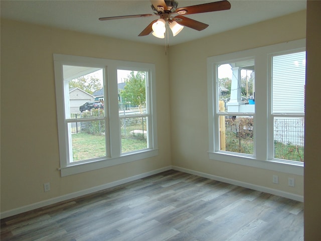 empty room featuring light hardwood / wood-style floors, a healthy amount of sunlight, and ceiling fan