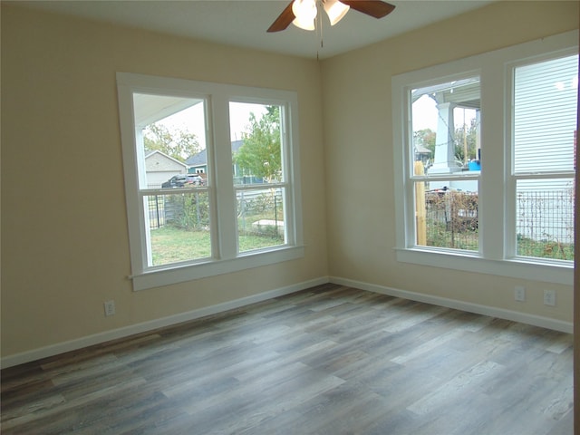 spare room with ceiling fan, hardwood / wood-style flooring, and plenty of natural light