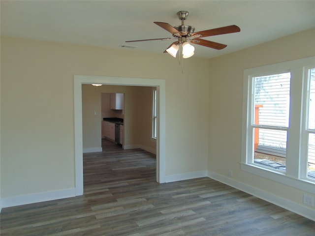 empty room with ceiling fan and dark hardwood / wood-style flooring