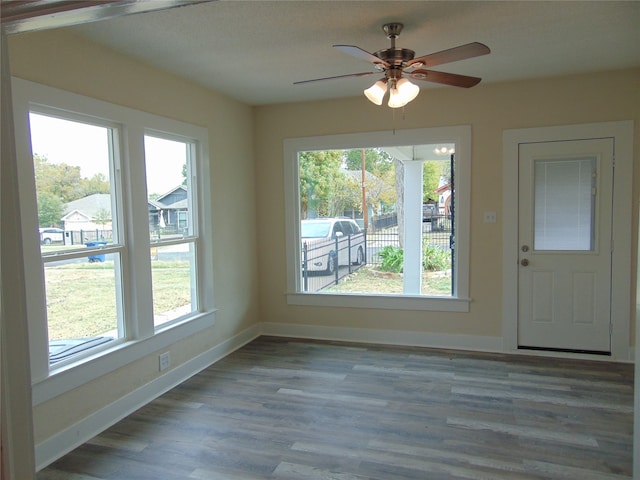 unfurnished dining area featuring a healthy amount of sunlight, hardwood / wood-style flooring, and ceiling fan