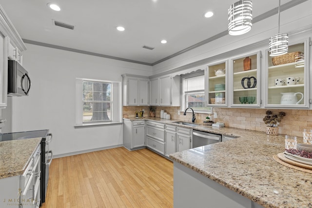 kitchen featuring crown molding, appliances with stainless steel finishes, plenty of natural light, and hanging light fixtures