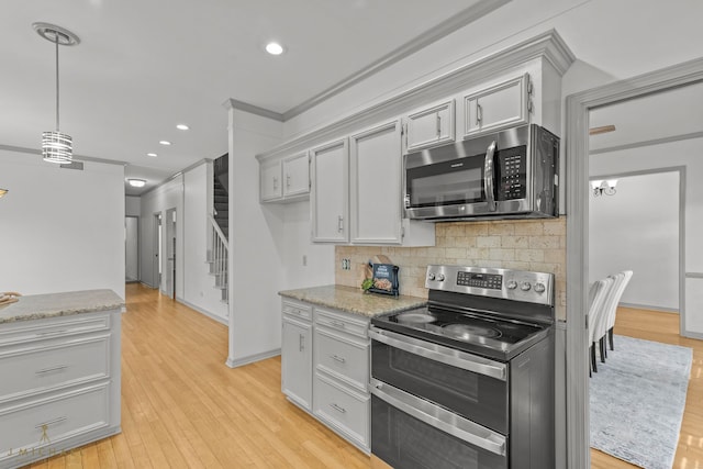 kitchen with light stone counters, stainless steel appliances, decorative backsplash, and light wood-type flooring