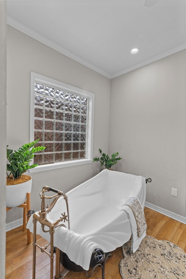 sitting room with crown molding and light wood-type flooring