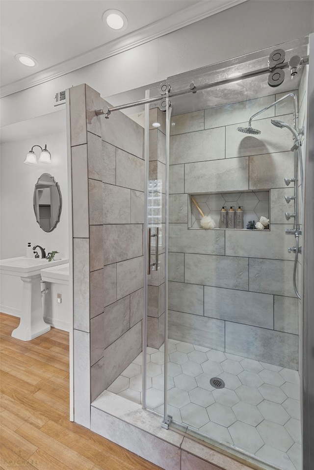 bathroom with crown molding, wood-type flooring, and walk in shower