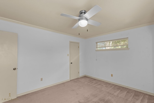 carpeted spare room featuring crown molding and ceiling fan